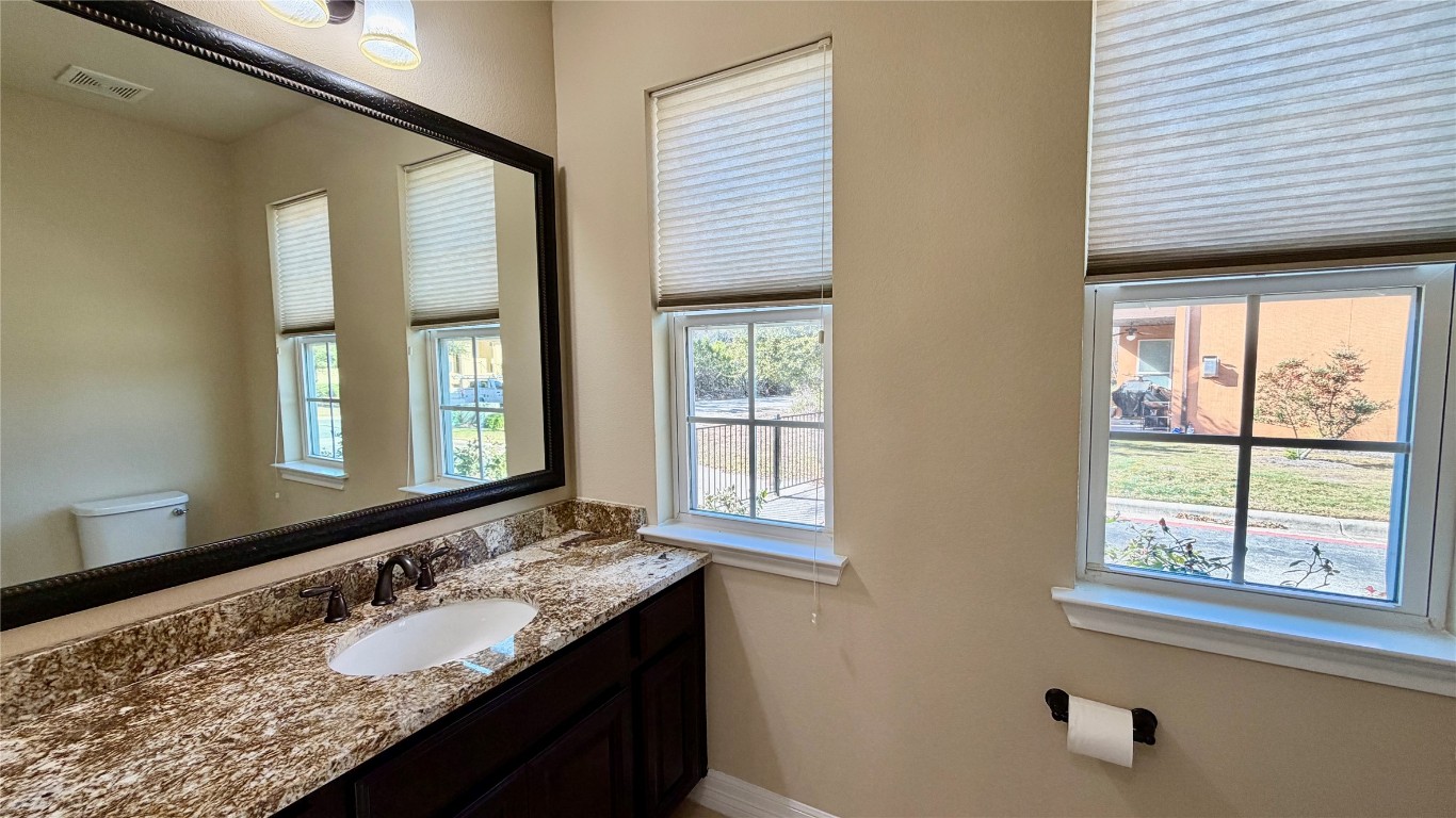 12300 Terraza Circle, Unit TH10 Austin, TX 78726 - Photo 17 of 36 a bathroom with a granite countertop sink and a large mirror