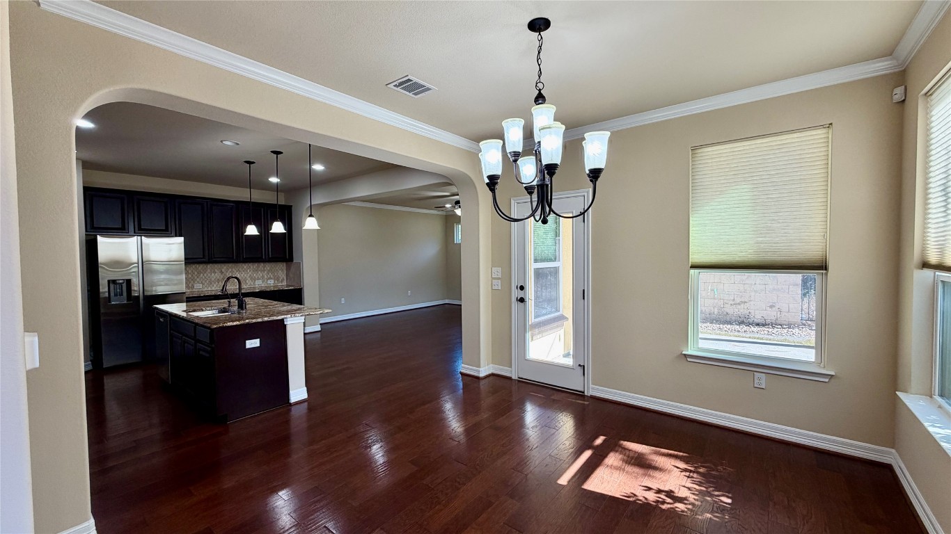 12300 Terraza Circle, Unit TH10 Austin, TX 78726 - Photo 35 of 36 a kitchen with stainless steel appliances granite countertop a refrigerator a sink dishwasher a stove and a dining table with wooden floor