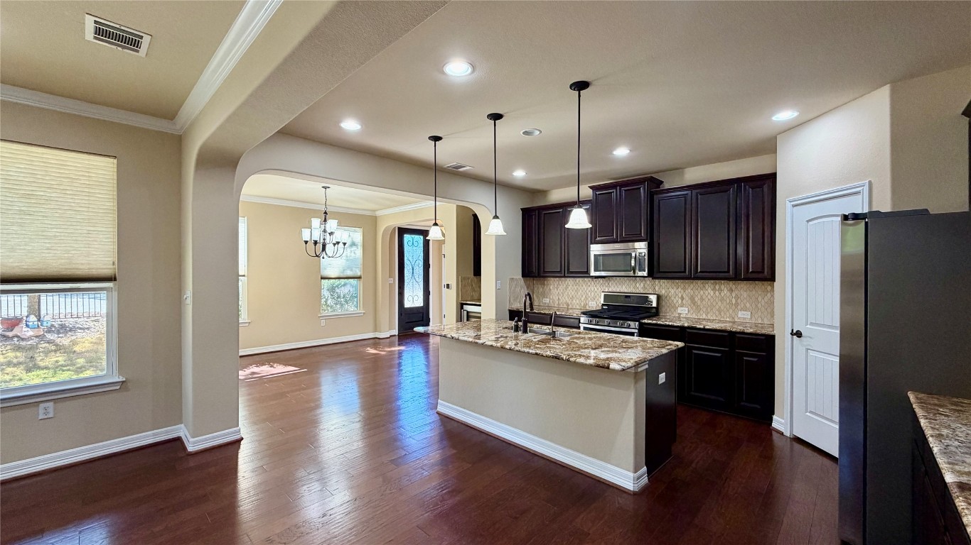 12300 Terraza Circle, Unit TH10 Austin, TX 78726 - Photo 5 of 36 a kitchen with stainless steel appliances granite countertop a refrigerator a stove top oven a sink dishwasher and a refrigerator with wooden floor