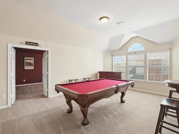 a pool table with window and chandelier