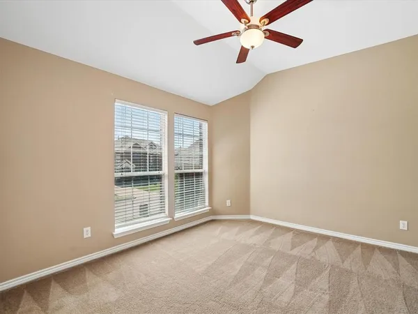 an empty room with windows and fan