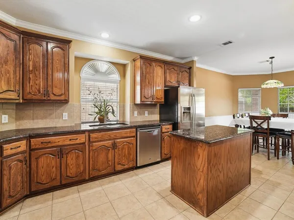 a kitchen with lots of counter top space dining table and stainless steel appliances