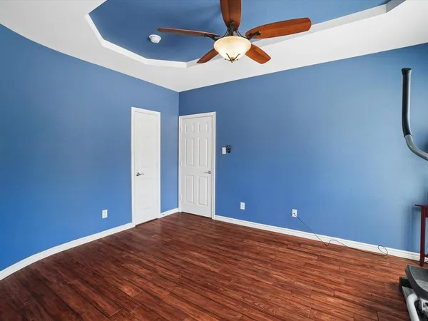 a view of a room with wooden floor and fan