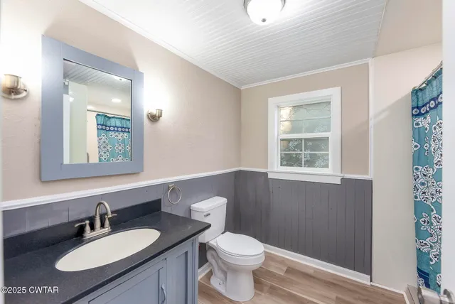 a bathroom with a granite countertop sink toilet and mirror