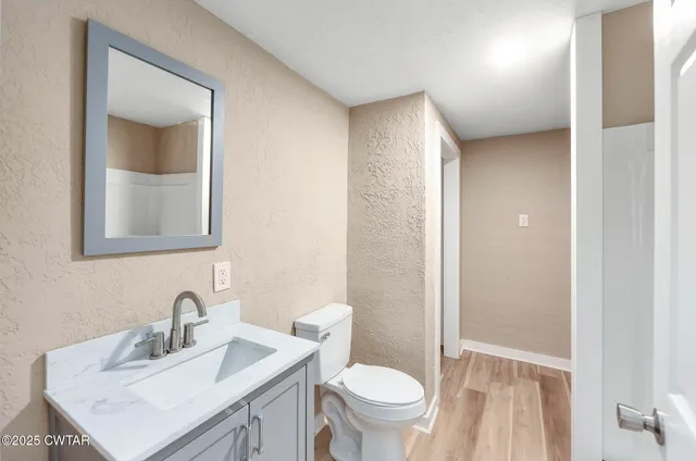 a bathroom with a sink toilet vanity and shower