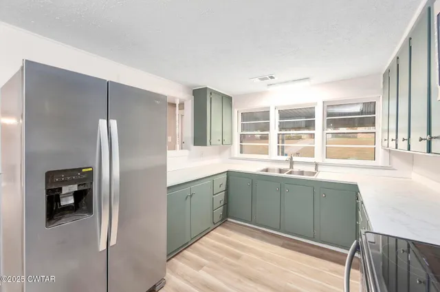 a kitchen with a refrigerator and a sink