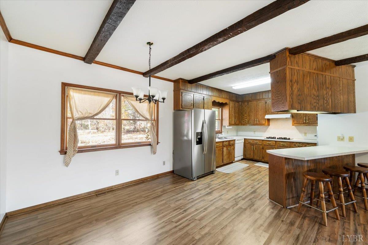 391 Pond Road Buckingham, VA 23921 - Photo 12 of 75 a kitchen with granite countertop a stove a sink dishwasher and a refrigerator with wooden floor