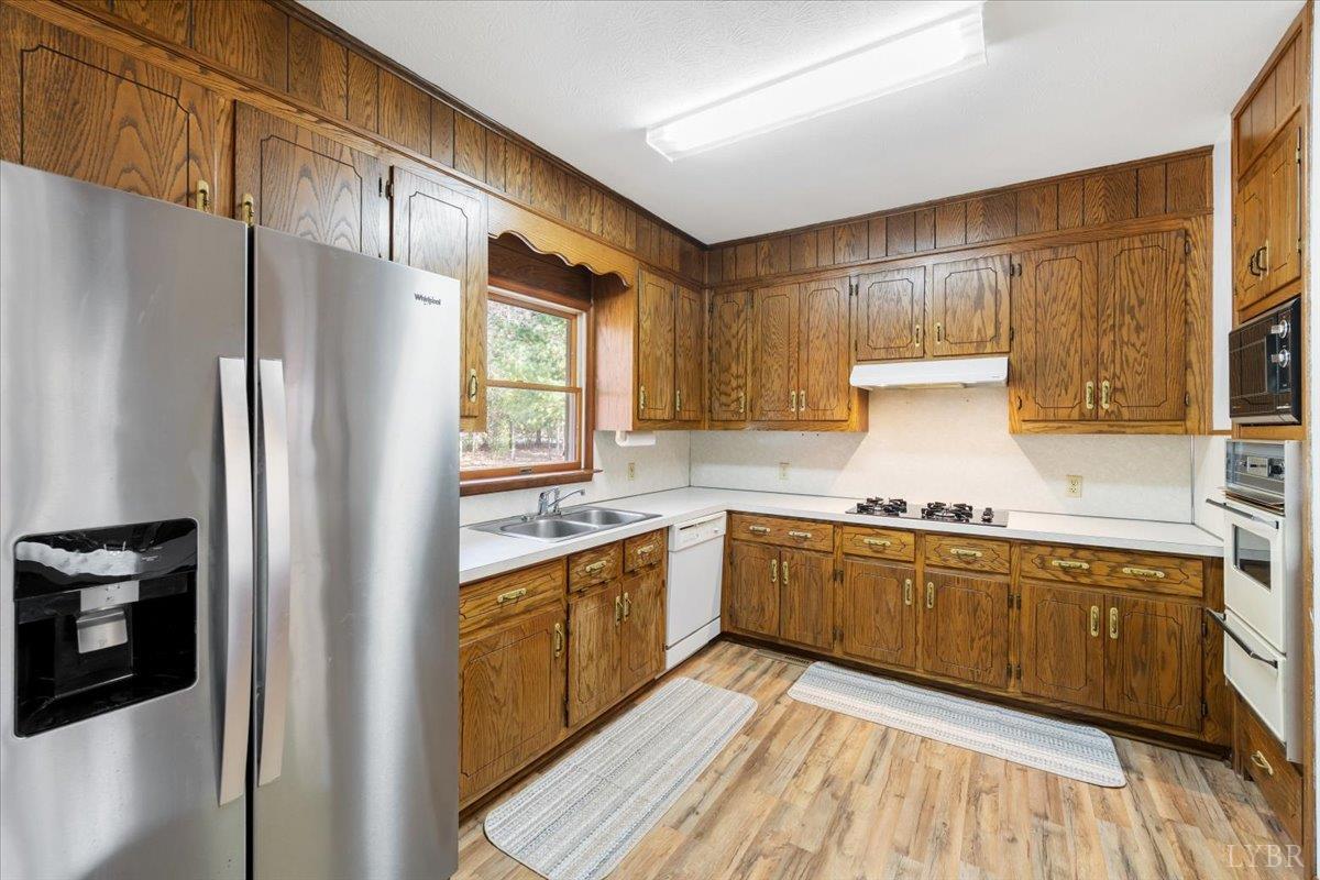391 Pond Road Buckingham, VA 23921 - Photo 15 of 75 a kitchen with stainless steel appliances granite countertop a refrigerator a sink dishwasher a stove and white countertops with wooden floor