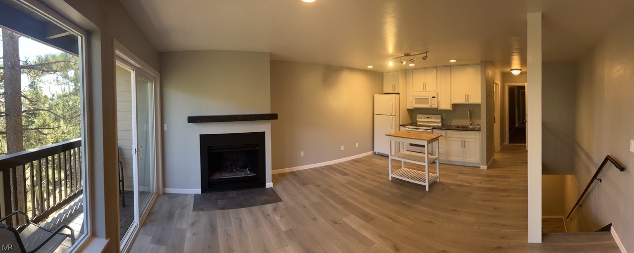 115 Tramway Drive, Unit 2 Stateline, NV 89449 - Photo 2 of 18 a view of a hallway with wooden floor and a fireplace