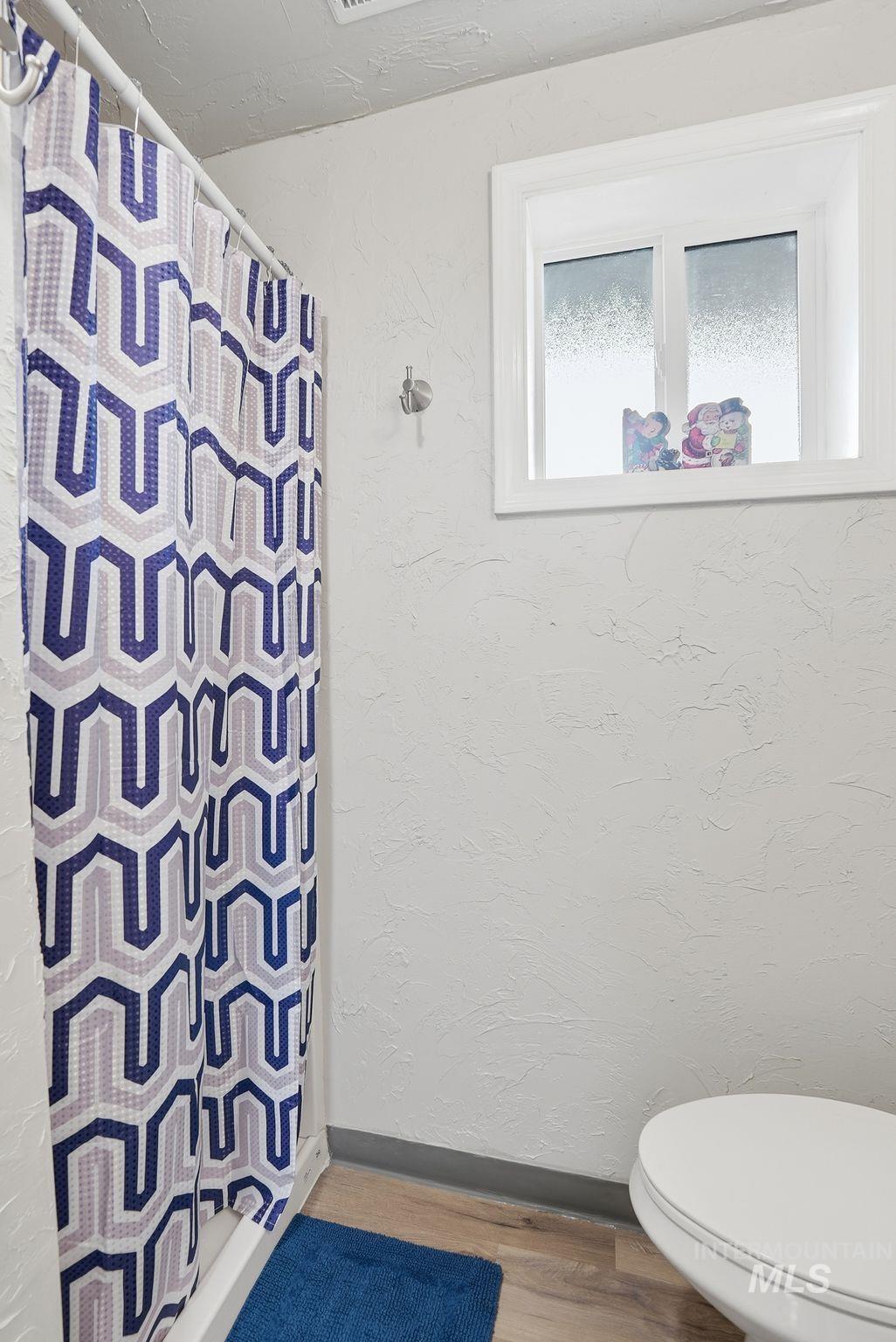 2435 Easy Street Clarkston, WA 99403 - Photo 20 of 49 Bathroom featuring a shower with curtain, a textured wall, and wood finished floors