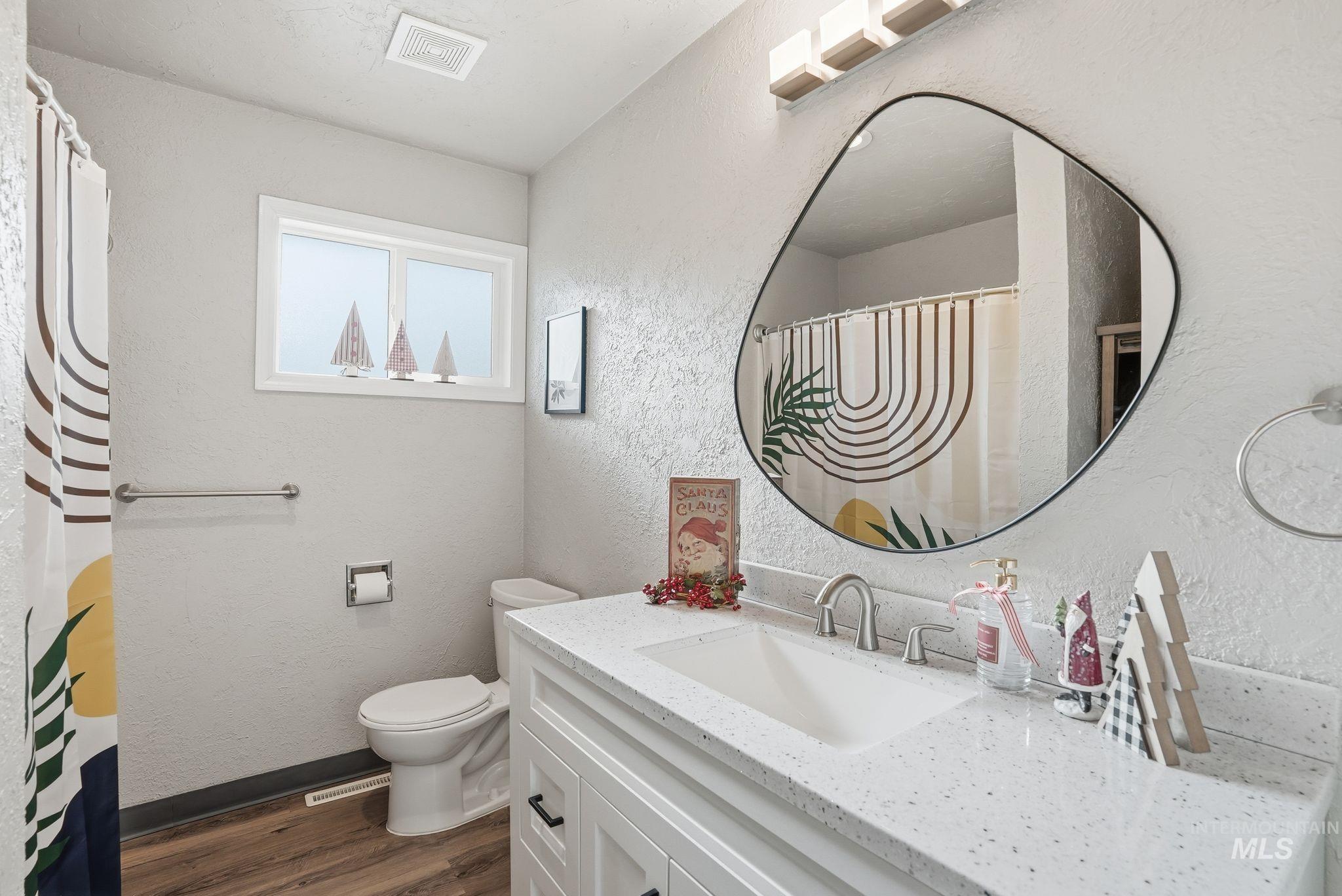 2435 Easy Street Clarkston, WA 99403 - Photo 24 of 49 Full bath featuring a textured wall, vanity, dark wood-style flooring, and a shower with curtain