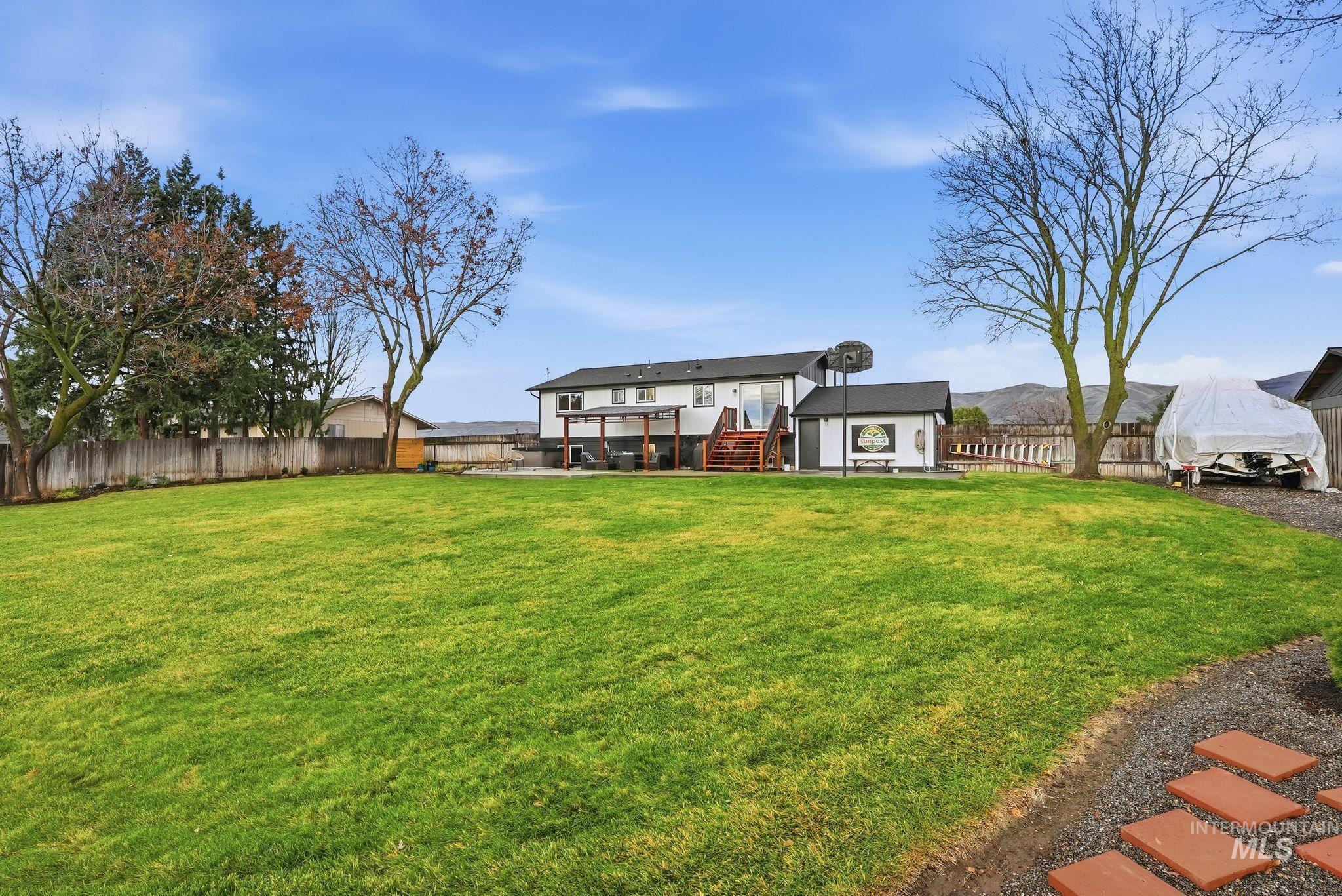 2435 Easy Street Clarkston, WA 99403 - Photo 43 of 49 Back of property featuring a fenced backyard, stairs, an outdoor structure, and a patio