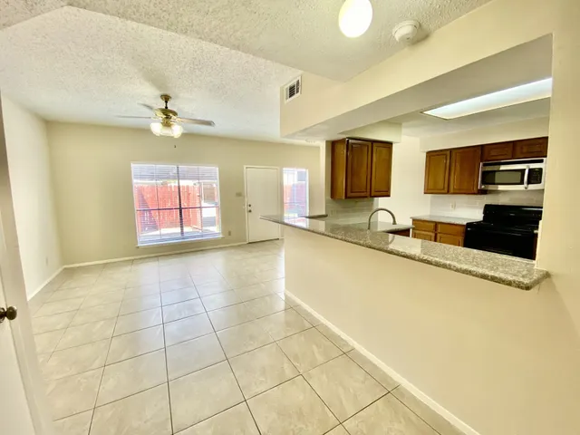 a view of a kitchen with granite countertop a sink and a counter top space