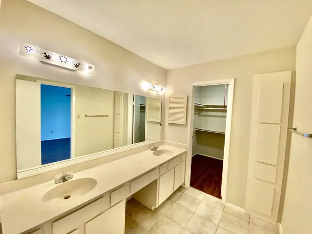 a spacious bathroom with a tub sink and mirror