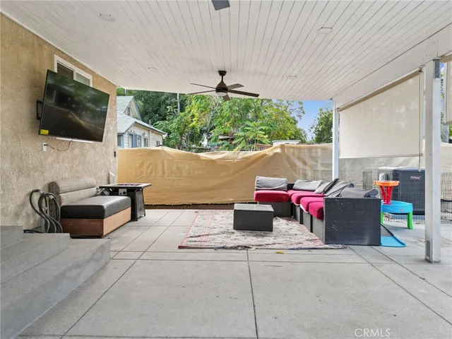 a living room with patio furniture and a flat screen tv