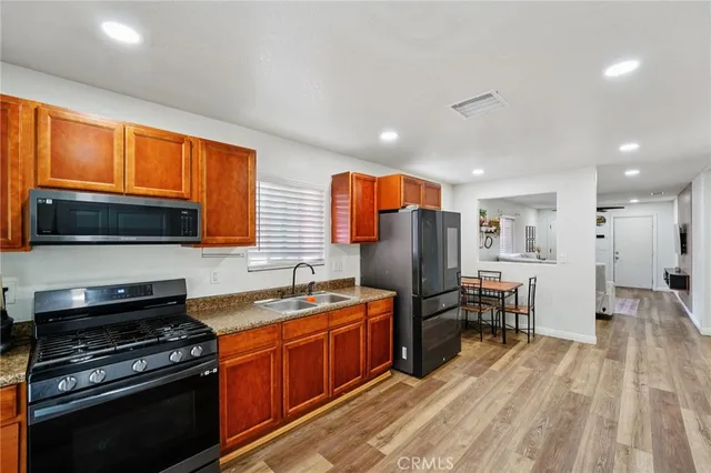 a kitchen with stainless steel appliances a stove sink microwave and cabinets