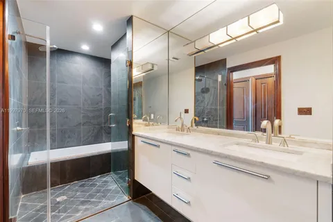 a bathroom with a toilet a double vanity sink and a mirror