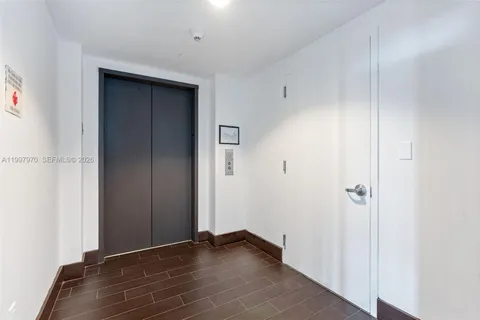 a hallway with wooden floor windows and stairs