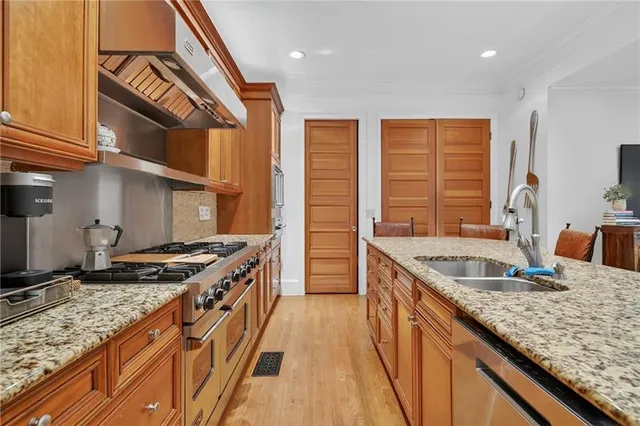 a kitchen with stainless steel appliances granite countertop a sink stove and cabinets