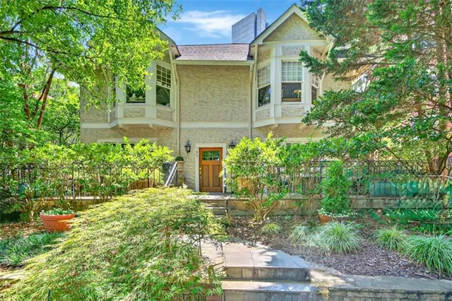 a view of a yard with plants and large trees
