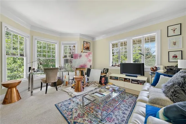 a living room with furniture a flat screen tv and a window