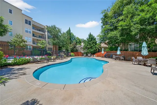 a view of a swimming pool with a lounge chair and couches in the patio