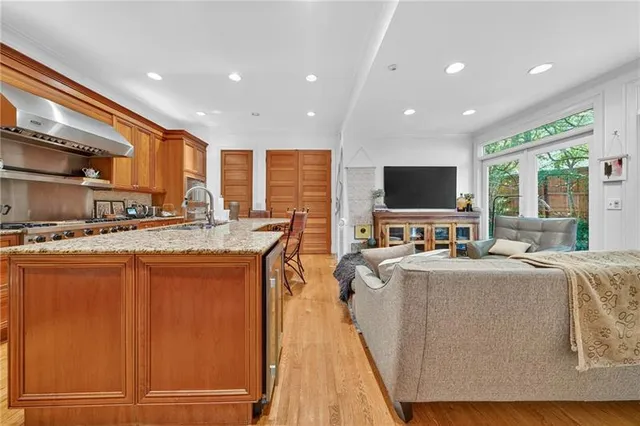 a living room with stainless steel appliances granite countertop furniture a flat screen tv and a faucet