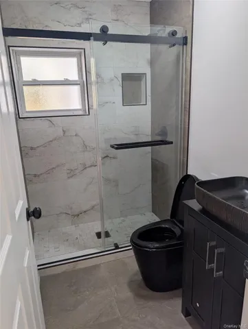 a bathroom with a granite countertop sink toilet and shower