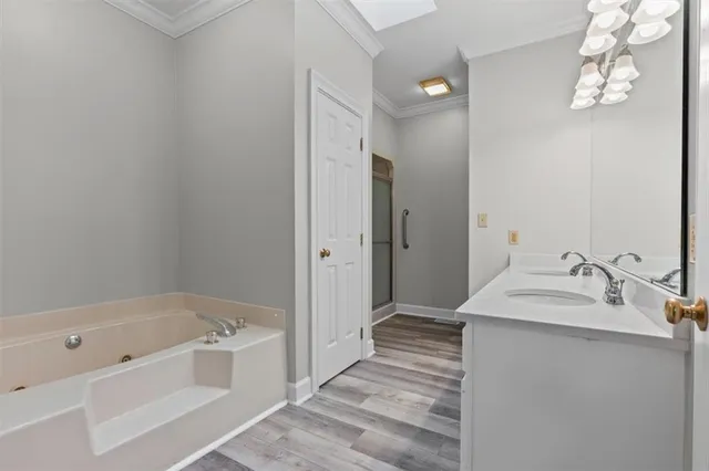 a bathroom with a tub sink and mirror
