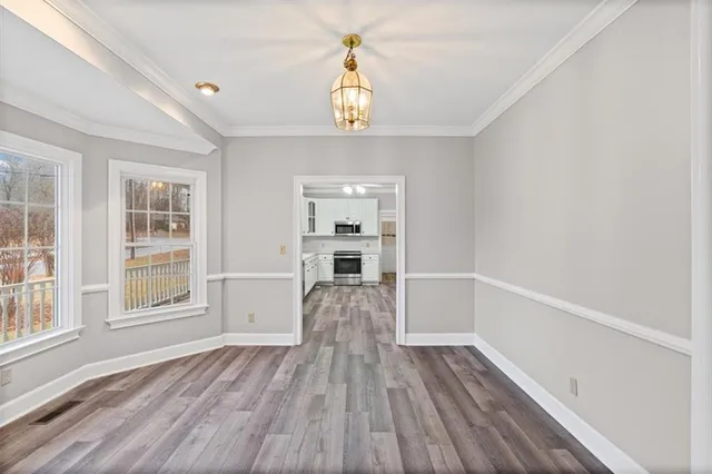 a view of empty room with wooden floor and window