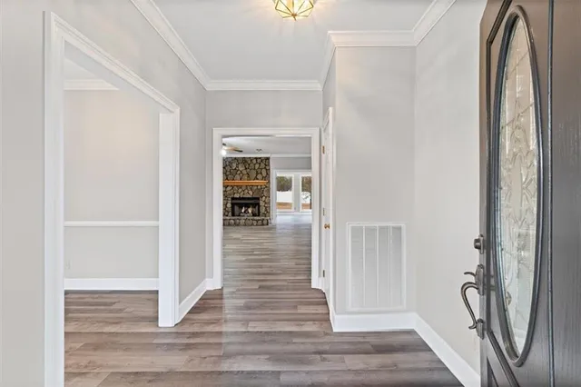 a view of a hallway with wooden floor and dining room