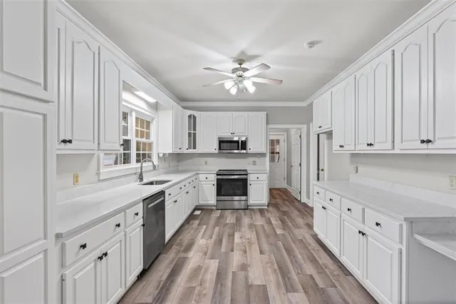 a large kitchen with cabinets a sink and appliances