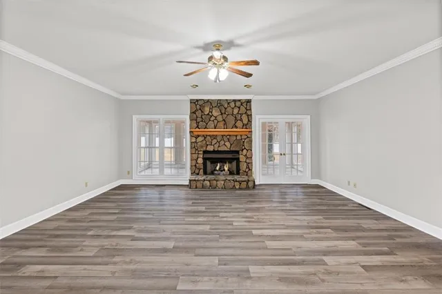 a view of an empty room with a window and fireplace