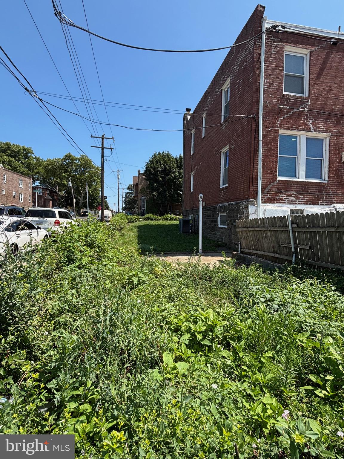6658 Rutland Street Philadelphia, PA 19149 - Photo 21 of 22 Overgrown lot beside a brick home.
