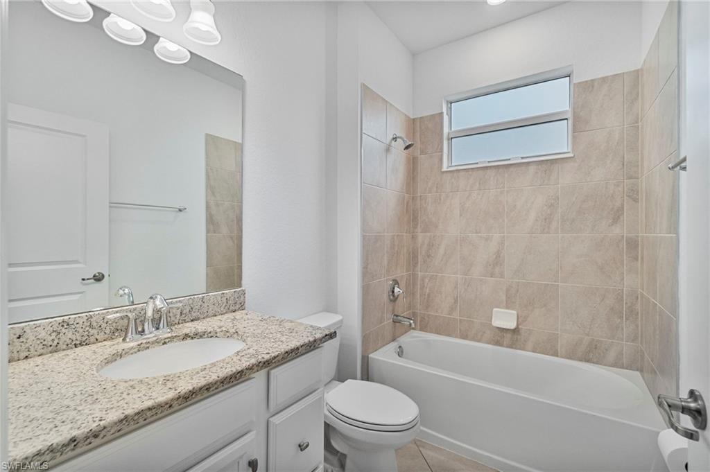 2118 Hamlin Street Naples, FL 34120 - Photo 15 of 41 a bathroom with a granite countertop sink a toilet and bathtub