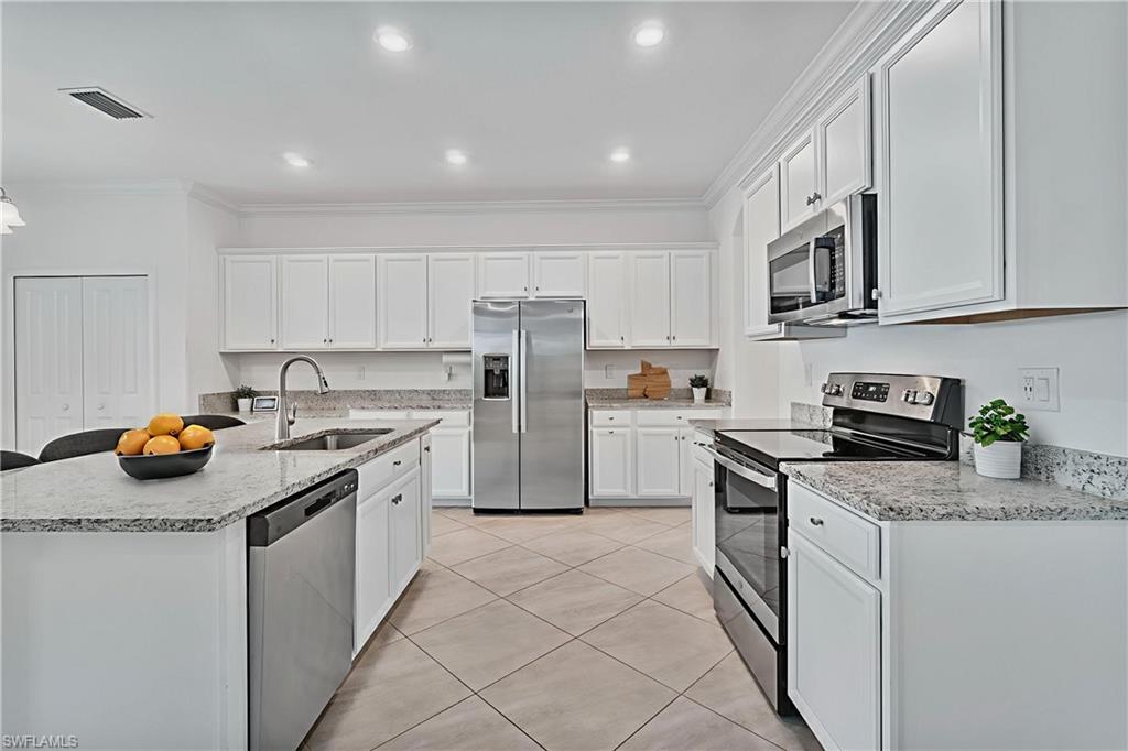2118 Hamlin Street Naples, FL 34120 - Photo 9 of 41 a kitchen with stainless steel appliances granite countertop a stove a sink and a refrigerator