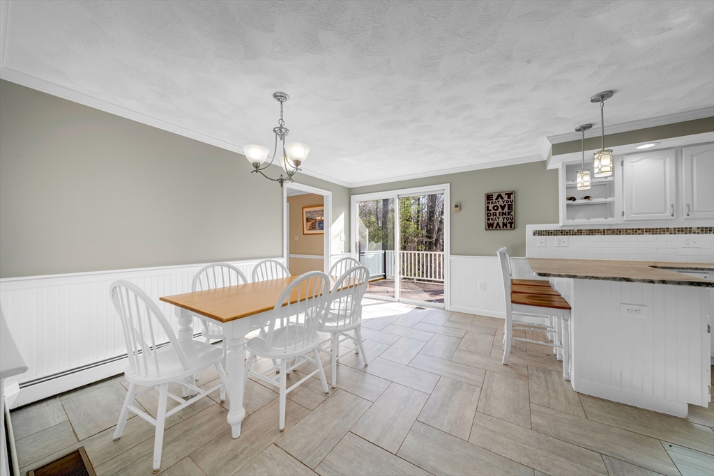315 Candlestick Road North Andover, MA 01845 - Photo 12 of 42 a dining hall with granite countertop a stove a sink a dining table and chairs with wooden floor