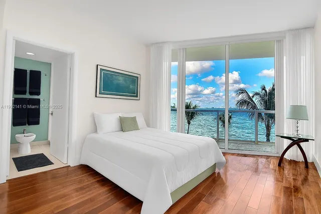 a bedroom with a bed and a large window