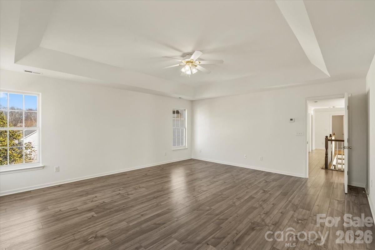 7215 Conifer Circle Indian Trail, NC 28079 - Photo 21 of 34 an empty room with wooden floor ceiling fan and windows