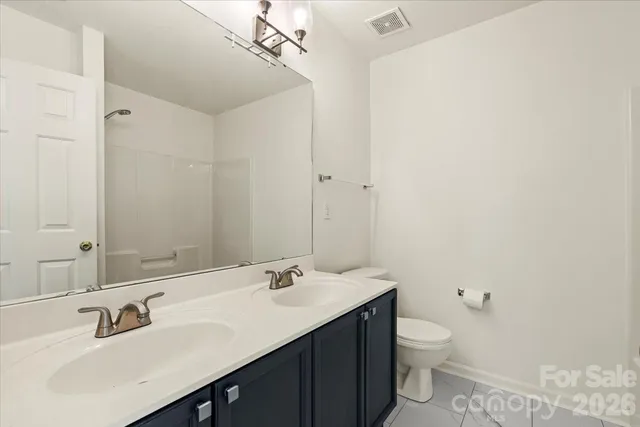 a bathroom with a sink double vanity and a toilet