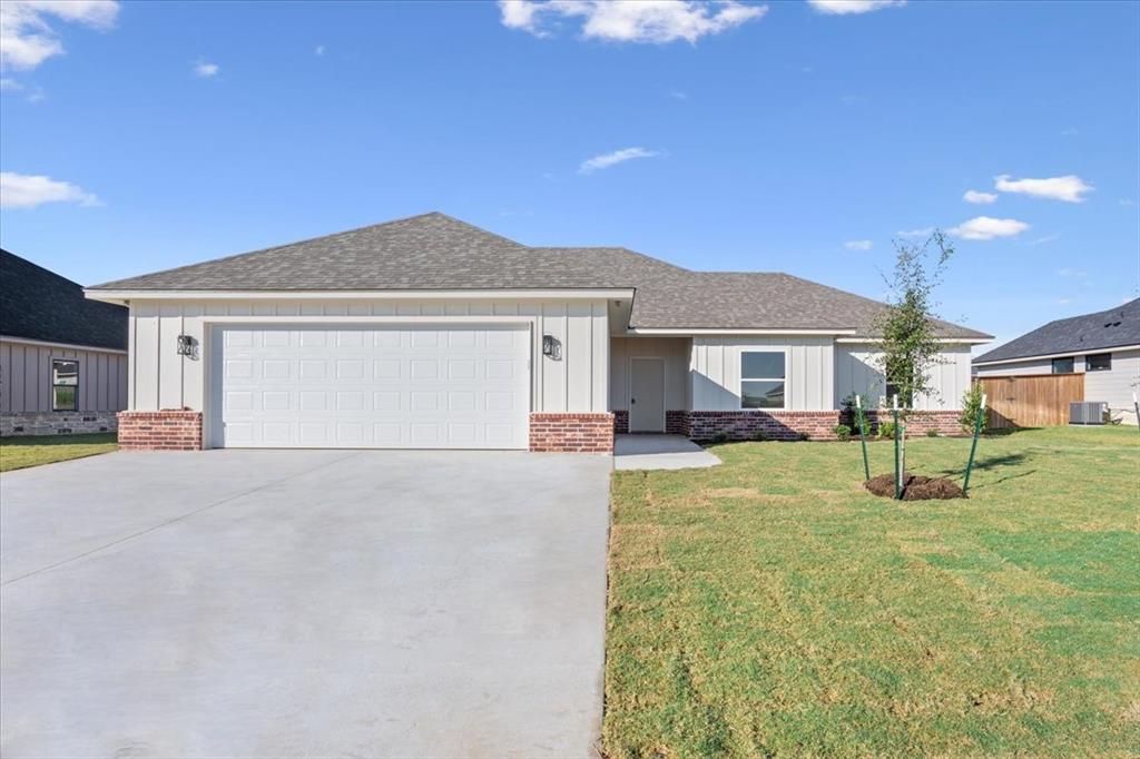 110 Great Trail Road Riesel, TX 76682 - Photo 1 of 1 Single story home featuring board and batten siding, a front yard, roof with shingles, driveway, and an attached garage