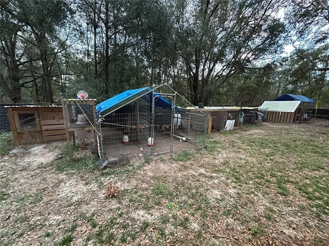 a view of house with wooden deck and outdoor seating