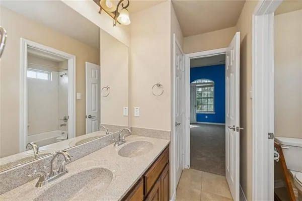 a bathroom with a granite countertop sink a mirror and a shower