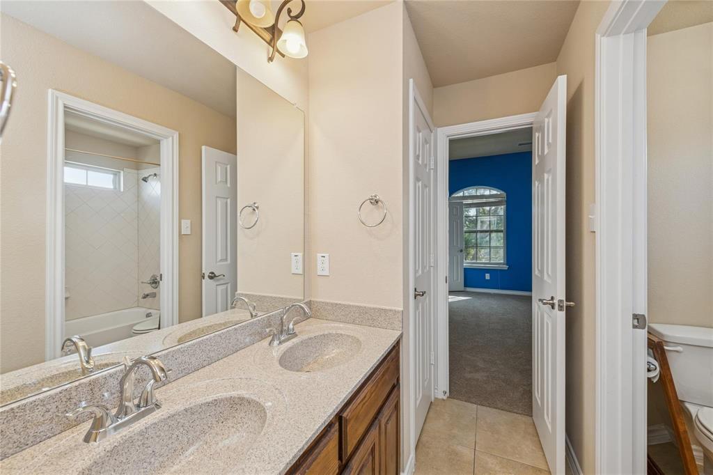 425 Windward Drive Murphy, TX 75094 - Photo 14 of 31 a bathroom with a granite countertop sink a mirror and a shower