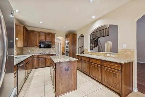 a kitchen with granite countertop a sink and cabinets