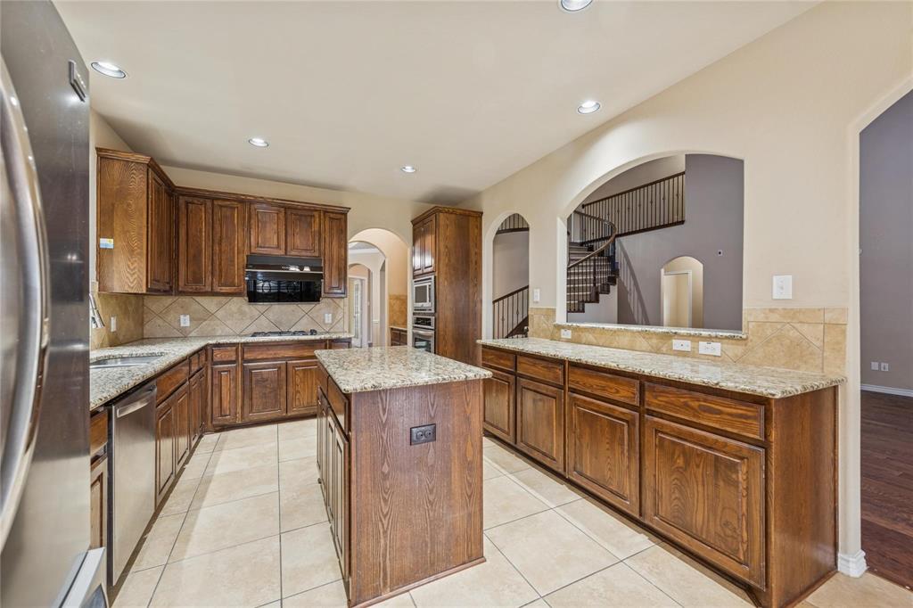 425 Windward Drive Murphy, TX 75094 - Photo 20 of 31 a kitchen with granite countertop a sink and cabinets