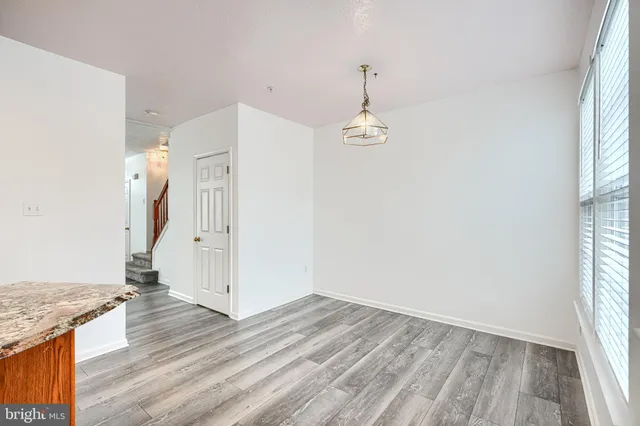 an empty room with wooden floor and entrance