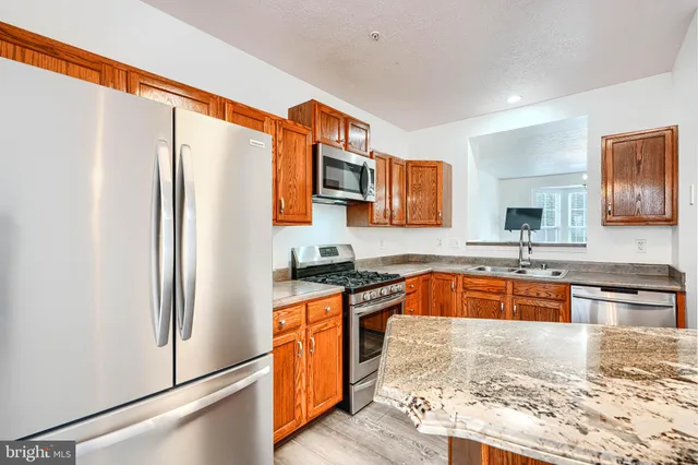 a kitchen with stainless steel appliances granite countertop a refrigerator and a sink