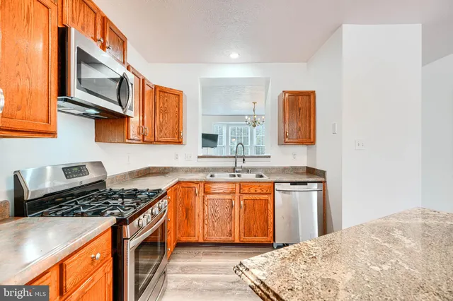 a kitchen with stainless steel appliances sink stove and cabinets