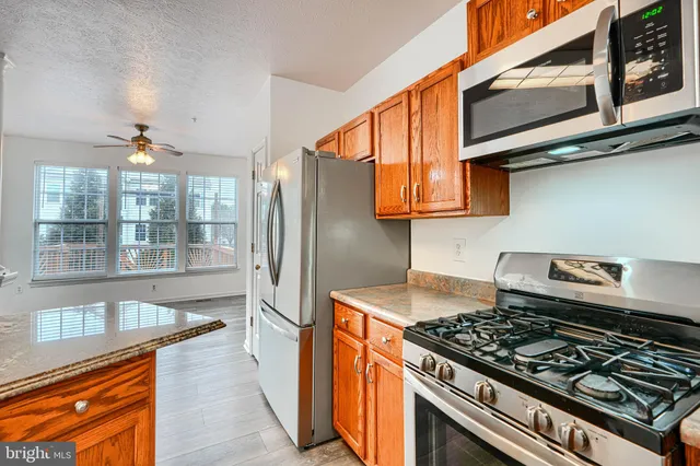 a kitchen with stainless steel appliances granite countertop a stove and a refrigerator